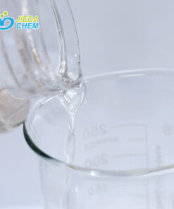 The transparent liquid Isononyl Isononanoate contained in the small bottle is being poured into the beaker